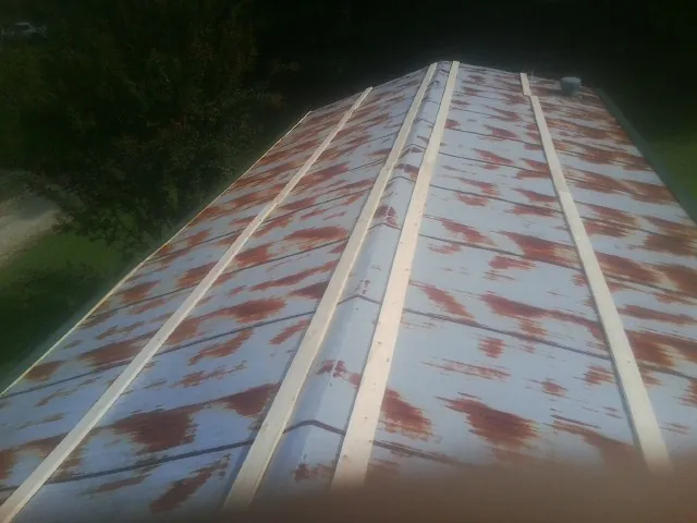 Rusted metal roof panels with new wood purlins before replacement — Storm Damage Roof Repair in Mears by Roofing Brothers