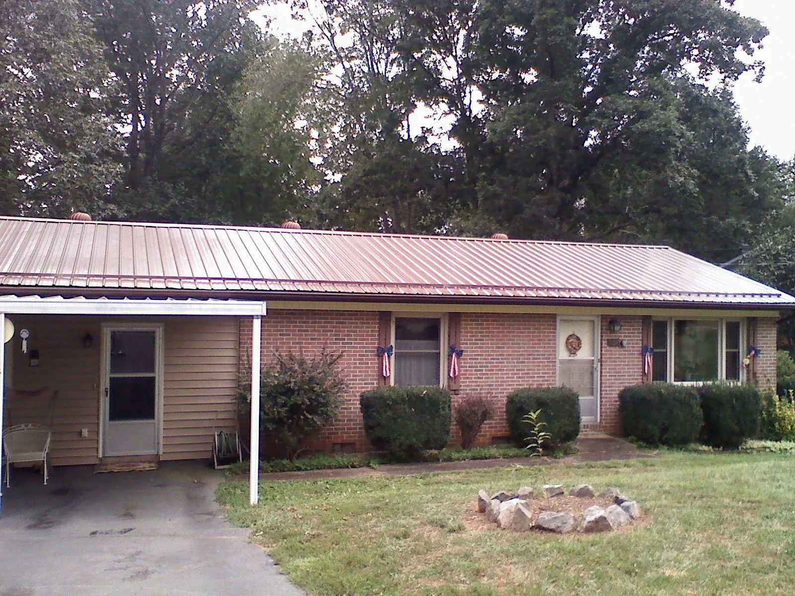 Bronze metal roof and carport on a brick ranch home — Roof Repair work by our crew in Mears